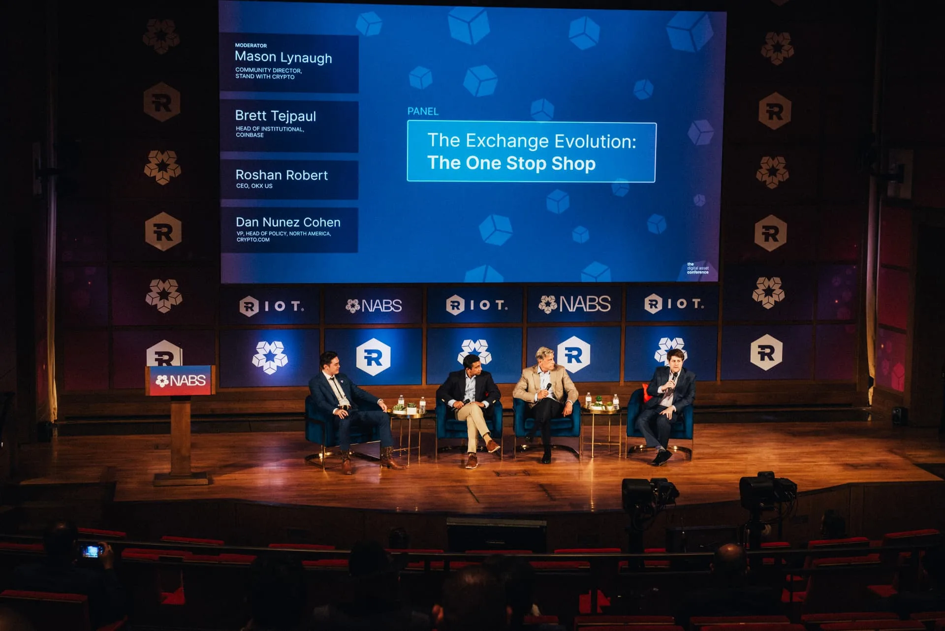 A moderated panel on a produced stage with a large LED screen