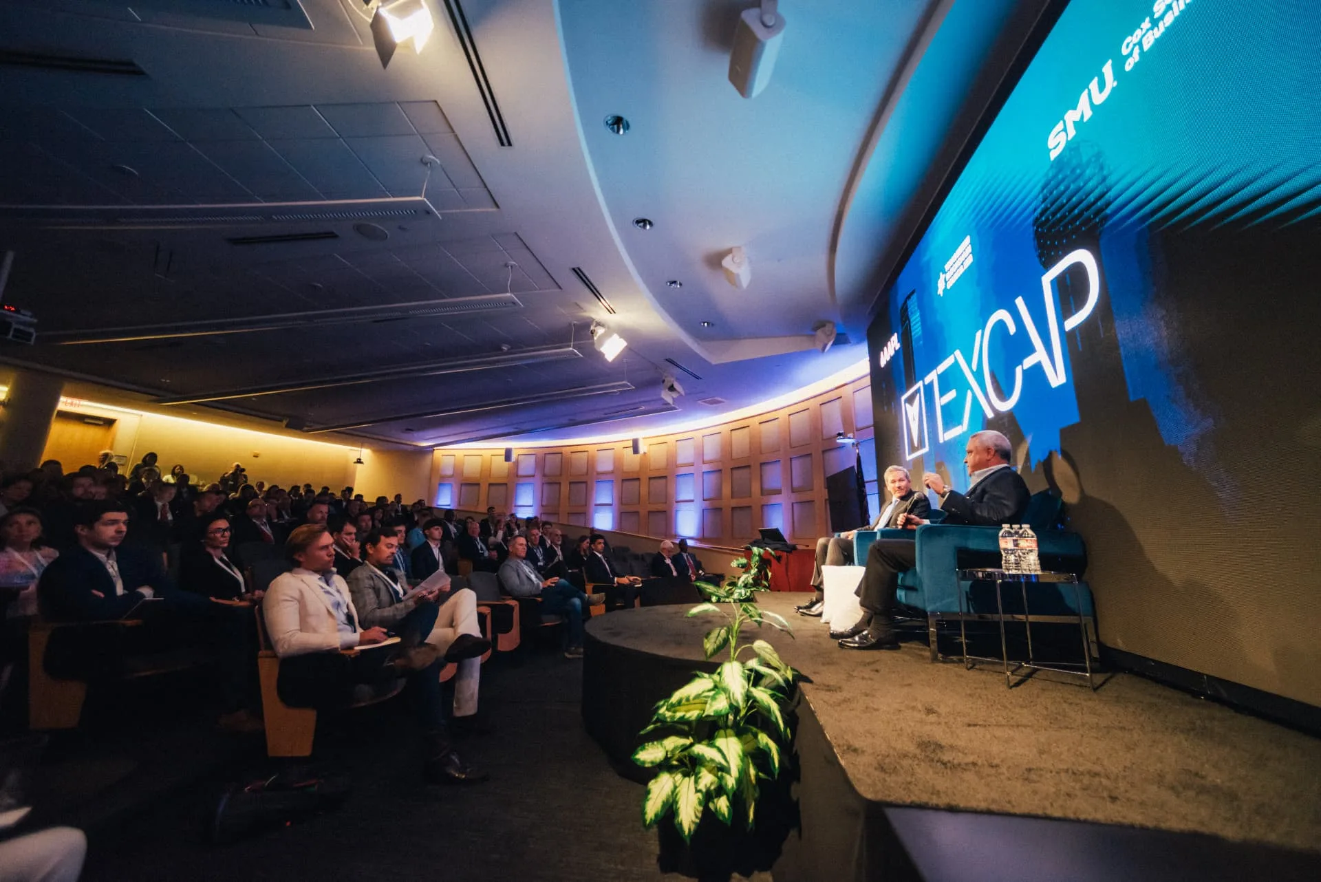 A fireside conversation on stage before a full auditorium audience
