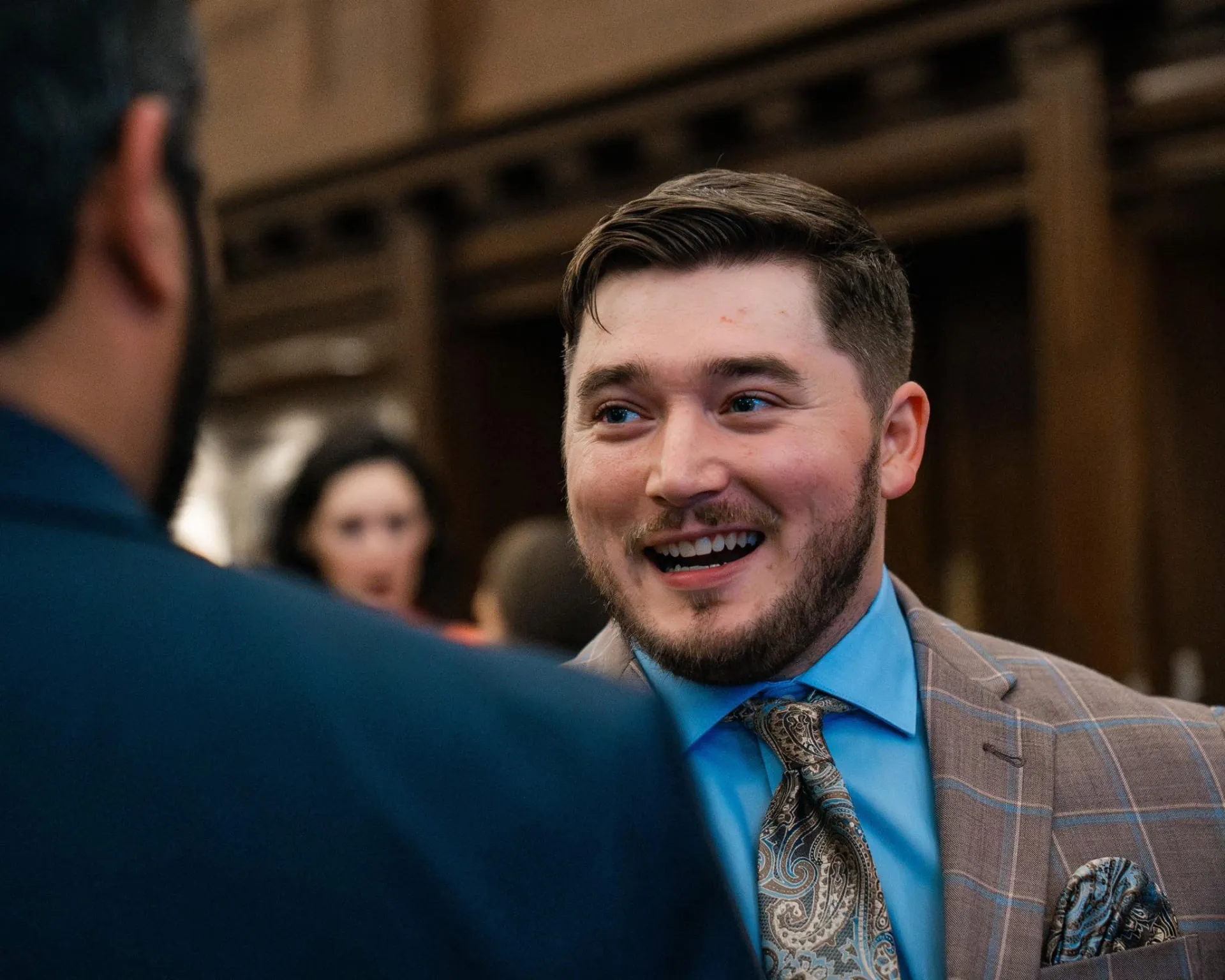 Tyler Dozier laughing with an attendee at a networking reception